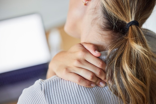 Foto stress da donna d'affari e laptop con dolore al collo stanco e lesioni dovute al lavoro o alla tensione in ufficio burnout lavoratrice oberata di lavoro e stressata massaggio mal di dolore e muscoli del collo sul posto di lavoro