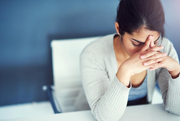 Business woman stress and tired in office with hands worried and anxiety at desk at startup Young businesswoman burnout and headache with anxiety frustrated or financial crisis in workplace