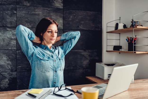 Business woman stretching arms in the office