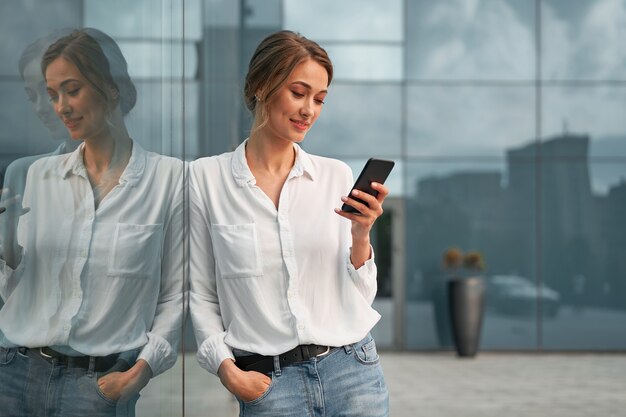 Uomo d'affari riuscito della donna della donna di affari all'aperto con il telefono cellulare