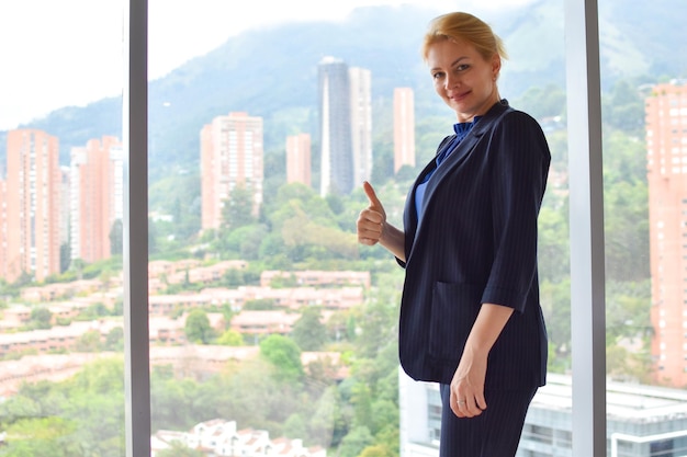 business woman in a suit near the panoramic window in  office girl in a business jacket at work