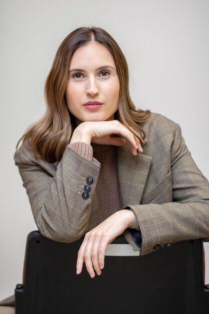 Business woman in suit sitting on chair