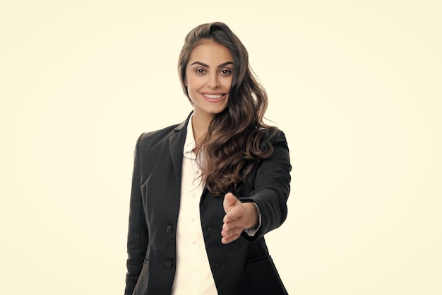 Business woman in suit smiling friendly offering handshake as greeting and welcoming successful