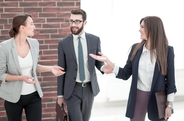 Business woman talking to colleagues standing in the office