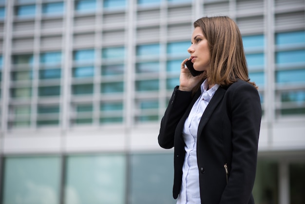 彼女の携帯電話で話しているビジネス女性