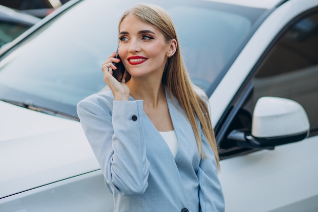 Donna d'affari che parla al telefono vicino alla sua auto