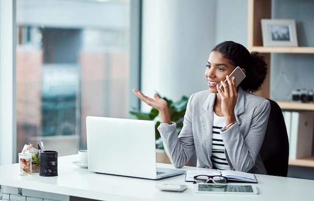 Photo business woman talking on phone call networking and discussing a strategy while sitting at a desk alone at work one happy corporate female professional making conversation while working in office