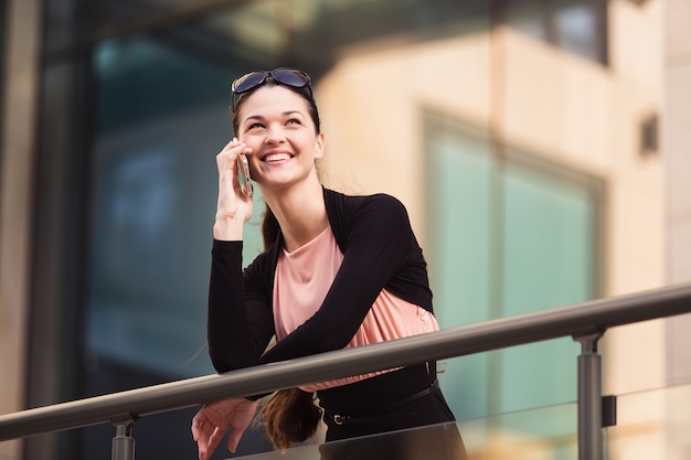 Donna di affari che parla al telefono durante una pausa caffè fuori dall'ufficio