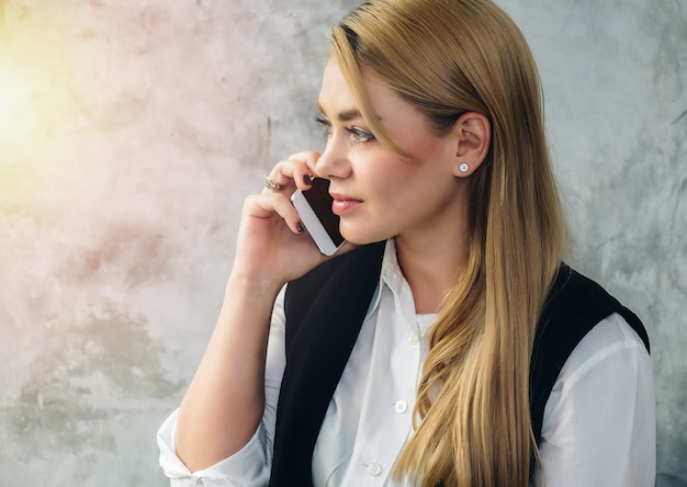 Business woman talking on the phone with a smartphone.