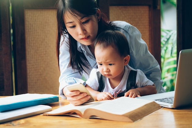 ビジネスの女性は、マルチメディアと本、ホームスクールで彼女の子供を教える。