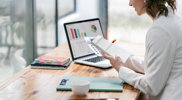 Photo business woman using calculator and laptop for analyzing the situation on the market