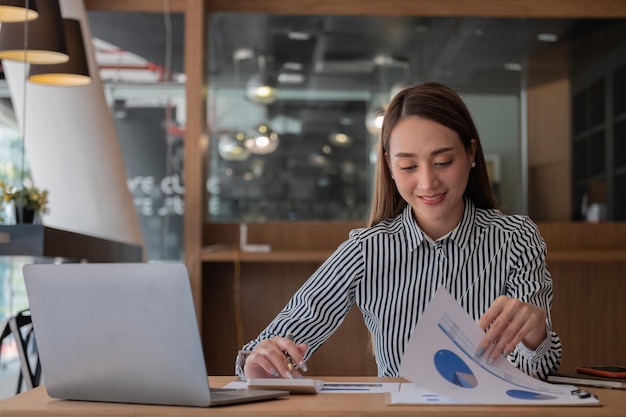 Business woman using calculator for do math finance on wooden desk in office tax accounting statistics home accounring concept