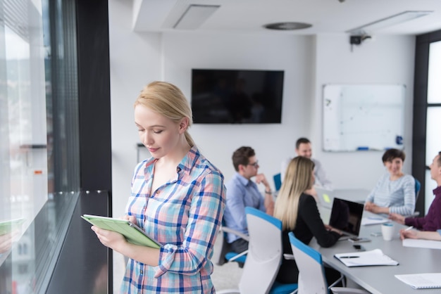 Business Woman Using Digital Tablet in corporate office by window