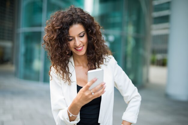 彼女の携帯電話を使用してビジネスの女性