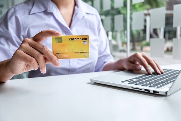 Business woman using laptop and holding credit card for paying detail page display online shopping