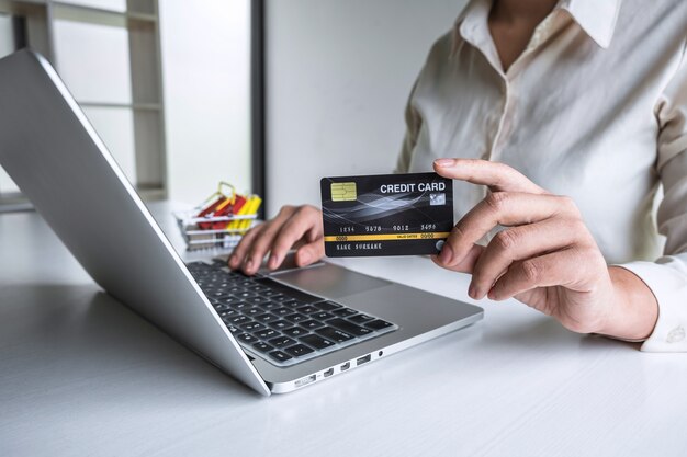 Business woman using laptop and holding credit card for paying detail page display online shopping