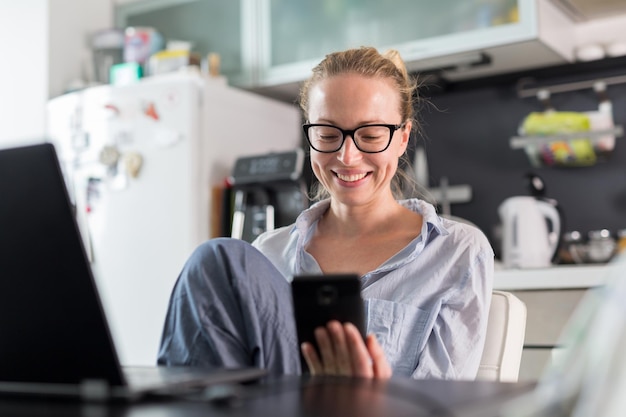 business woman using smart phone while sitting at home