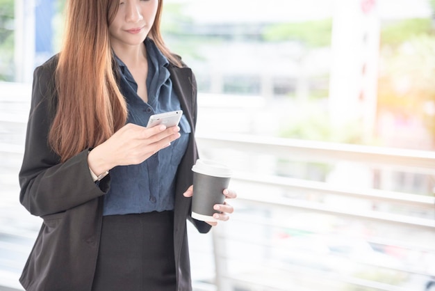 Business woman using smartphone shopping online call texting\
message internet technology lifestyle asian woman using cellphone\
walking on city street smart phone smart confident woman modern\
city
