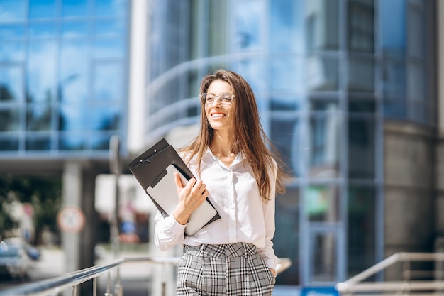 Business woman using tablet near modern business center.