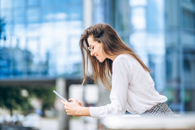 Business woman using tablet near modern business center.