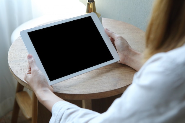 Business woman using tablet  with holding on wooden desk