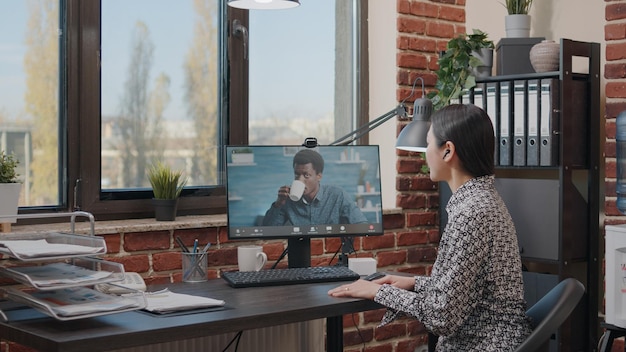 Business woman using video call meeting to talk to colleague in\
office. entrepreneur chatting with man on online video conference\
about project planning and strategy. online conference