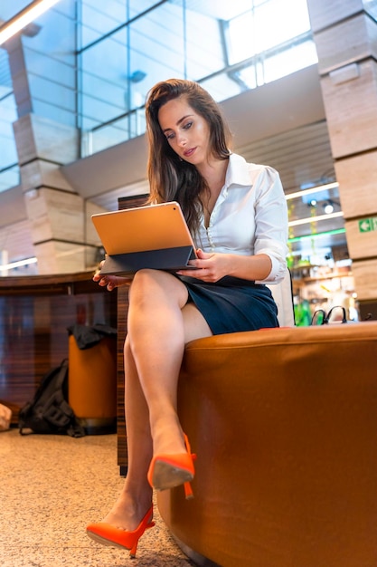 Business woman waiting for her next flight in an airport terminal