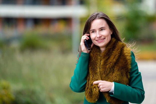 A business woman walking down the street in a financial district talking on the phone