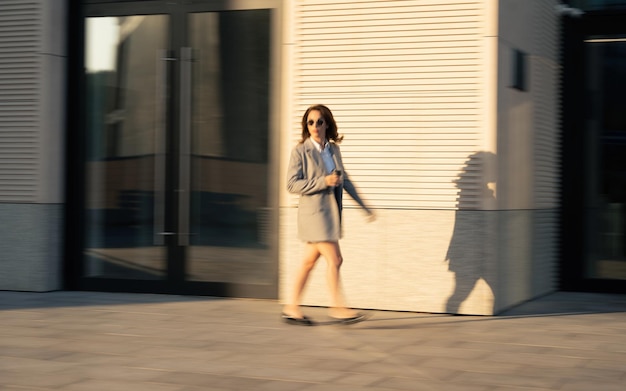 Business woman walking drinking coffee Lawyer professional or similar walking outdoors happy holding paper cup