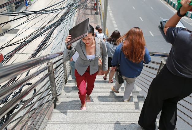 Business woman walking overpass stairs at sunny day.