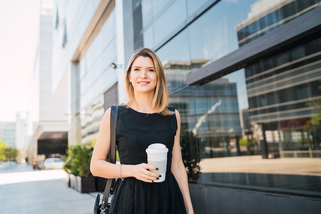 Business woman walking to work while drinking coffee.