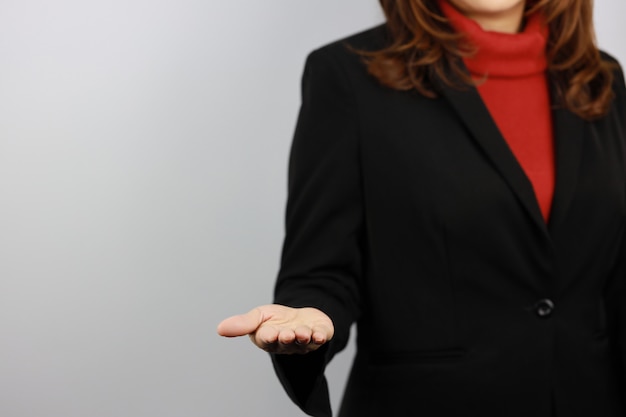 Business woman wearing black and red business suit uniform with confident while showing something on her hand   