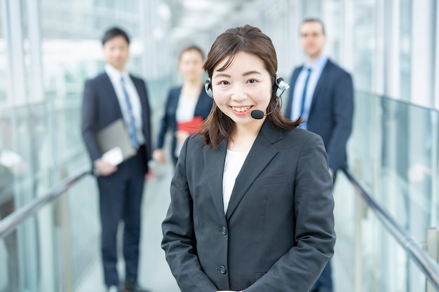 Business woman wearing a headset and her business team