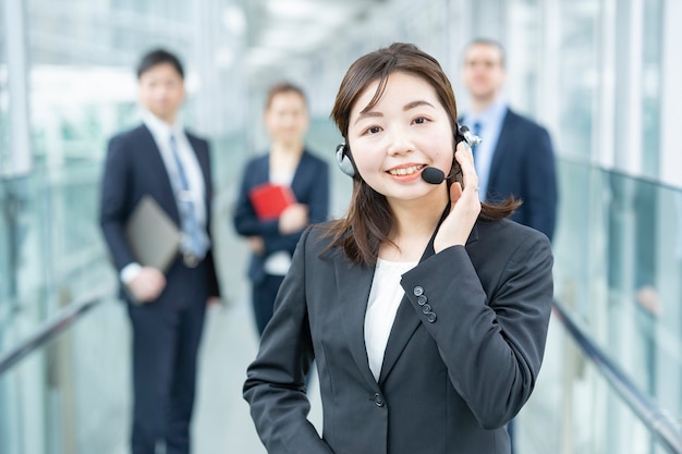 Business woman wearing a headset and her business team