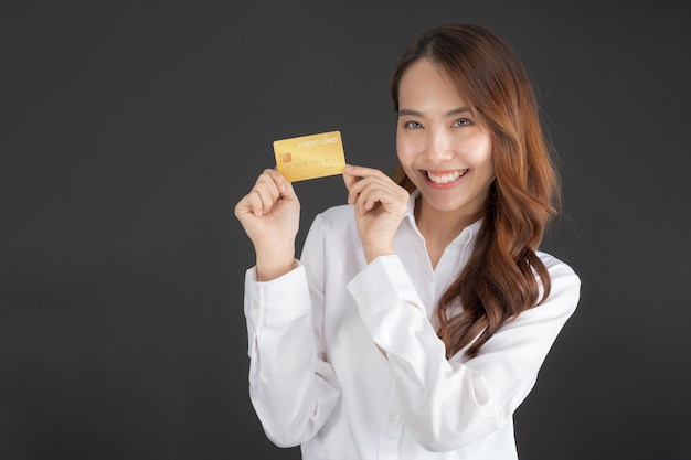 Business woman wearing white shirt standing holding credit card