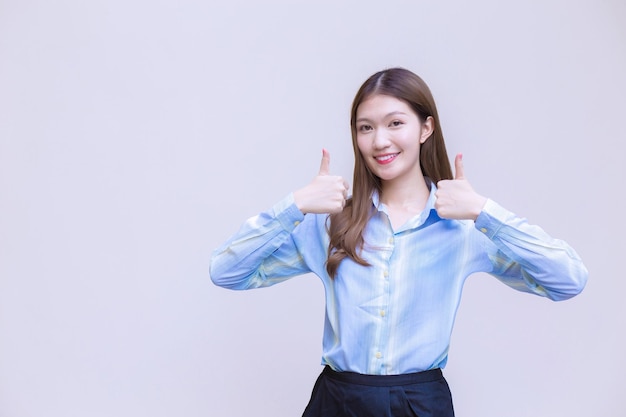 Business woman who has long hair Asian with blue shirt smiles and shows thumb up present something