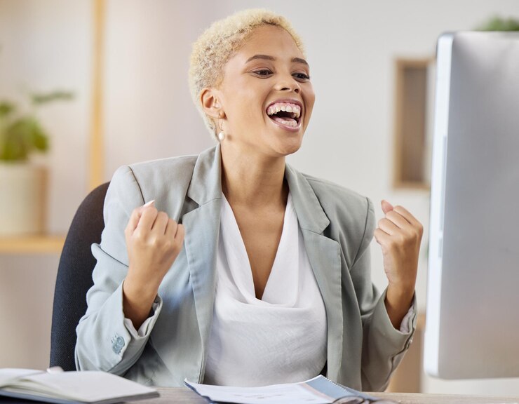 Photo business woman and winning fist in office for celebration promotion or good news email in office excited success and happy lady financial advisor with wow face for growth sale or startup loan