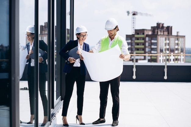 Foto donna d'affari con l'architetto che parla sul tetto dell'edificio in costruzione