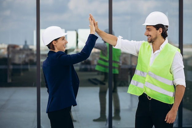 Business woman with architect talking on the roof of the\
construction building