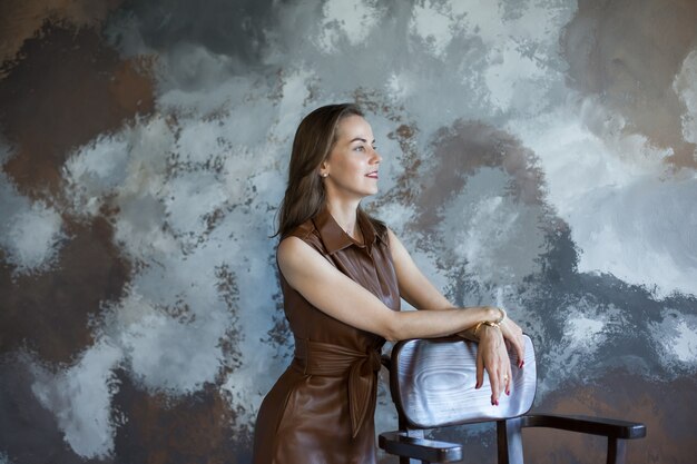 Business woman with brown hair in a brown dress