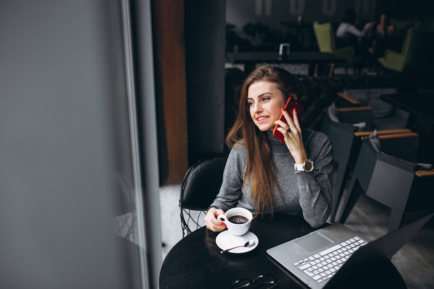 Business woman with coffee in a cafe working on computer