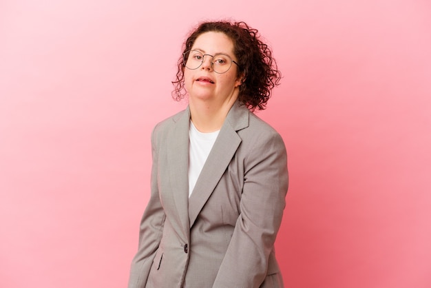 Business woman with Down syndrome isolated on pink background looks aside smiling, cheerful and pleasant.