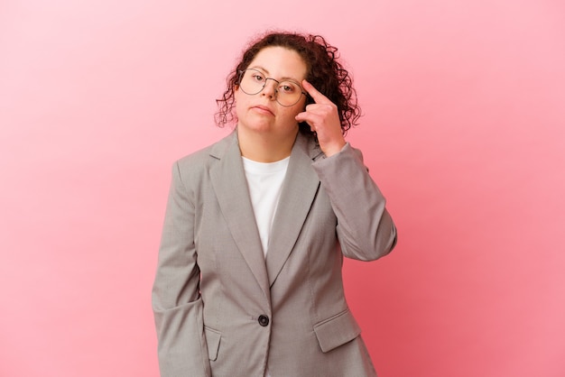 Business woman with Down syndrome isolated on pink wall showing a disappointment gesture with forefinger