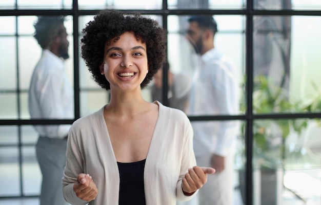 Photo business woman with her staff in background at office