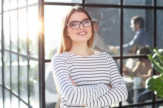 オフィスの背景にスタッフと一緒にいる女性ビジネスマン