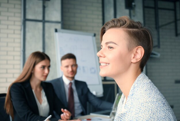 Business woman with her staff, people group in background at modern bright office indoors