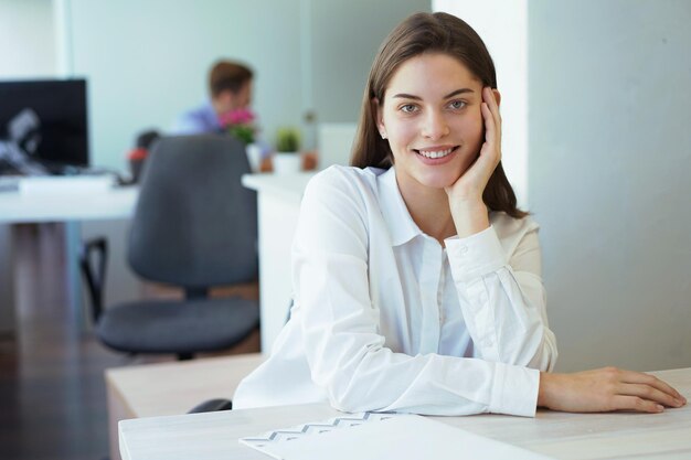 Business woman with her staff, people group in background at modern bright office indoors.