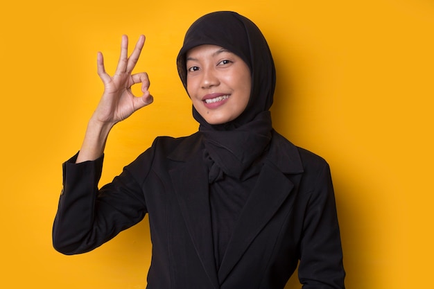 Деловая женщина с портретом в хиджабе, показывающим жест ОК