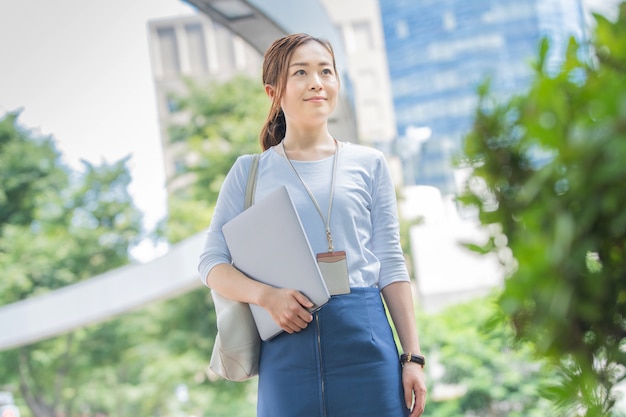 写真 屋外のラップトップを持つ女性実業家