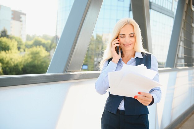 Business Woman With Phone Near Office Portrait Of Beautiful Smiling Female In Fashion Office Clothes Talking On Phone While Standing Outdoors Phone Communication High Quality Image